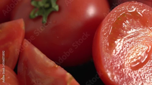 Ripe tomatoes slowly rotate on the table