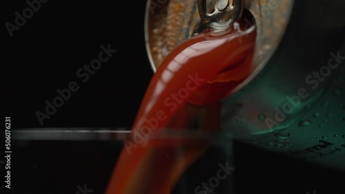 Tomato juice is poured into a glass