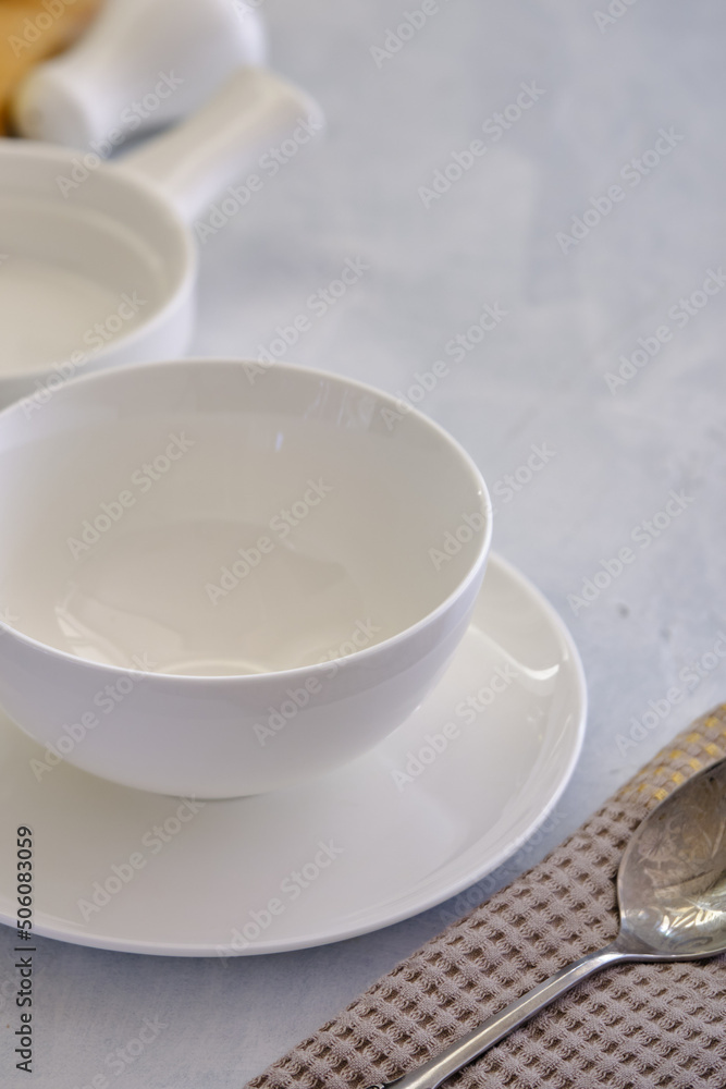 White ceramic plate with a bowl on a concrete table White ceramic plate with a bowl on a concrete table