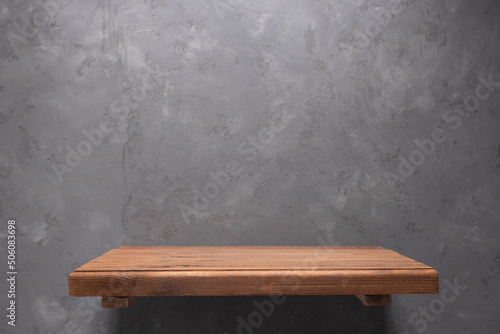 Wooden shelf at wall. Wood shelf on abstract concrete background