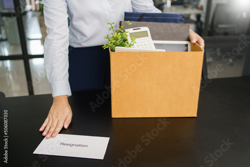 Resignation concept, Female employee holding stuff box and sending resignation letter to executive © Pichsakul