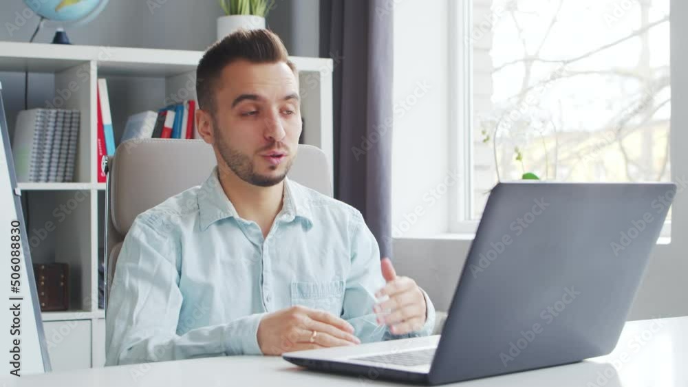 Young Teacher makes an Online Lesson while Sitting in Front of Computer at Home. The Workplace of the Tutor for School Lessons. Distant Study and Education Concept. Young Teacher makes an Online Lesson while Sitting in Front of Computer at Home. The Workplace of the Tutor for School Lessons. Distant Study and Education Concept.
