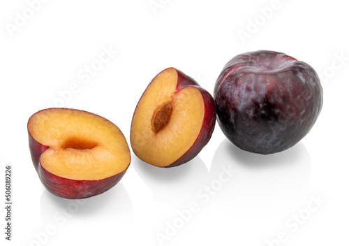 Black plums isolated on white, one whole and one cut in half. Clipping path