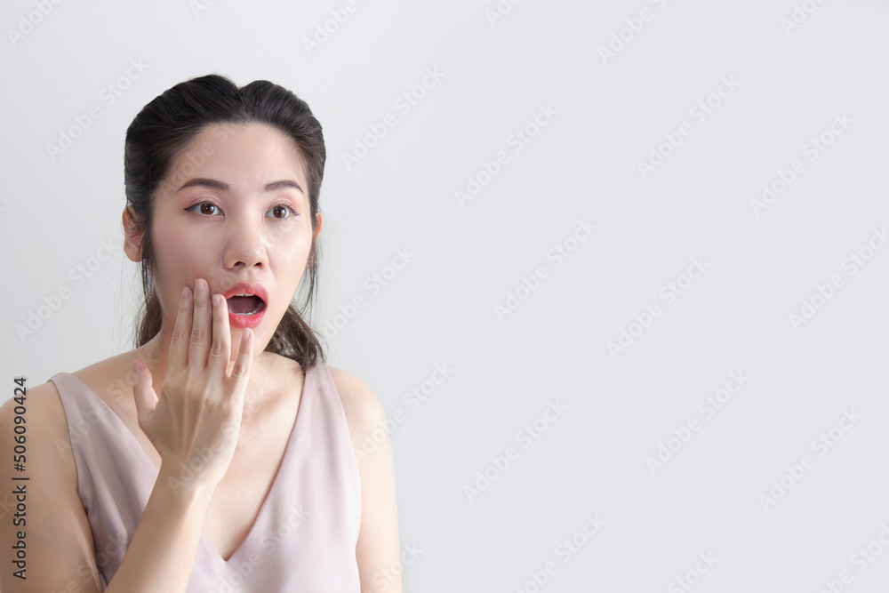 Asian beautiful woman raise hand touching her lips and open mouth and looking away with shocking and surprising Asian beautiful woman raise hand touching her lips and open mouth and looking away with shocking and surprising