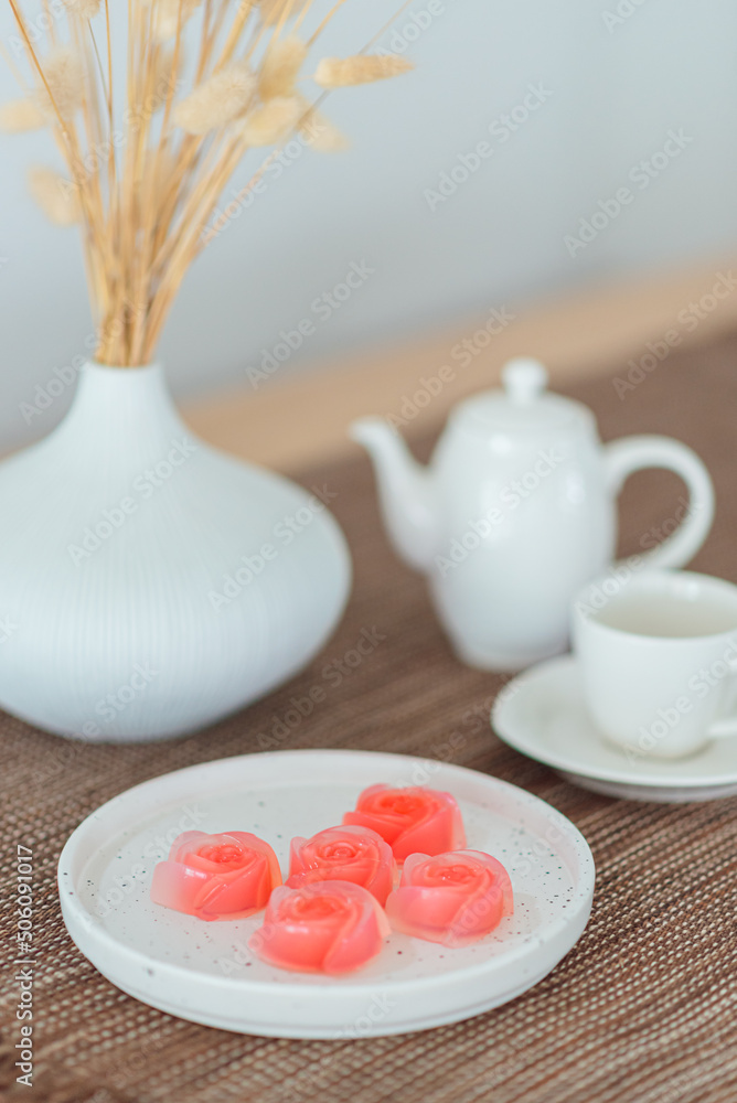 Pink jelly desserts with a set of tea on the table. (selective focus)