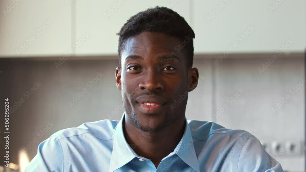 Young african american man looking at camera agreeing in conversation with colleague Young african american man looking at camera agreeing in conversation with colleague