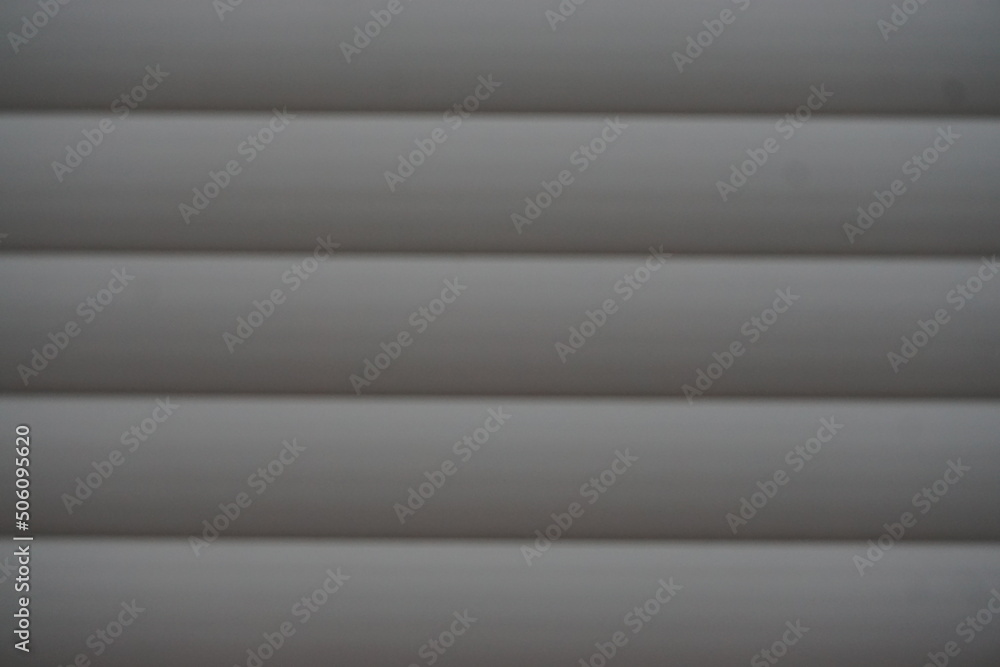 Graue gestreifte Aluminiumfläche von geschlossener Fensterjalousie Graue gestreifte Aluminiumfläche von geschlossener Fensterjalousie