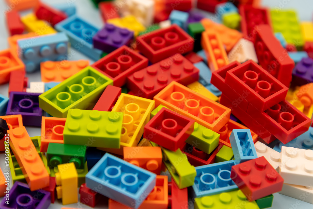 Close up of colorful plastic building block on blue background, school and education concept, high angle view, blue background Close up of colorful plastic building block on blue background, school and education concept, high angle view, blue background