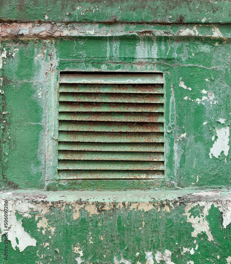 Dirty and rusty metal ventilation grill on a weathered green wall. Dirty and rusty metal ventilation grill on a weathered green wall.