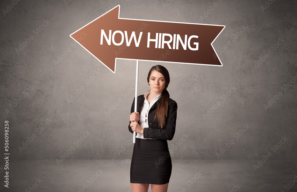 Young business person in casual holding road sign Young business person in casual holding road sign