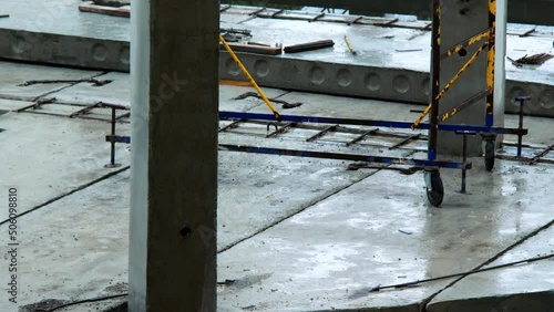 Construction site on the rain. Foundation, floors, concrete piers and piles of skyscraper. High rise building construction. Empty construction site of a large building under heavy rain. Bad weather