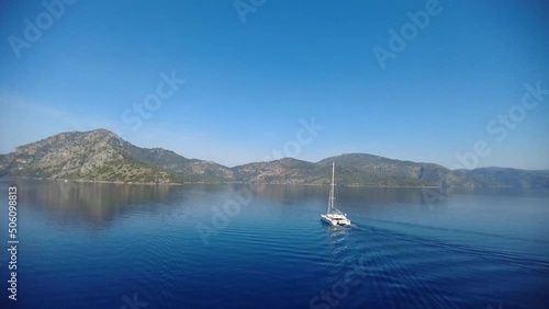 yacht floats in the sea shore with mountains 