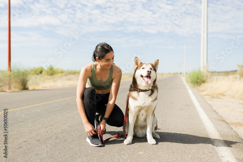 Smiling woman preparing for a run with her dog