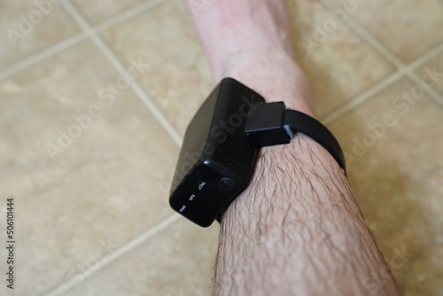House arrest GPS jail monitoring bracelet on the male ankle due to jail sentence.