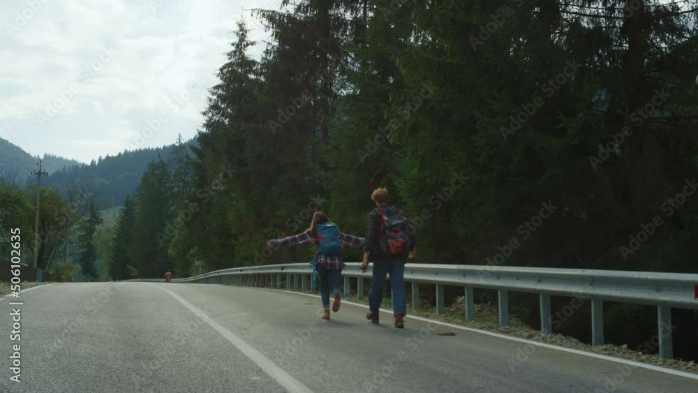 Friends trekking mountains road in forest nature. Couple wear backpacks outside. Friends trekking mountains road in forest nature. Couple wear backpacks outside.