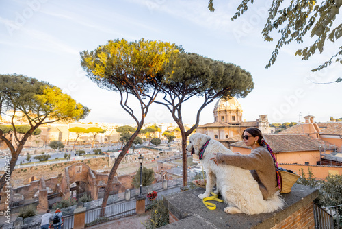 Canvas Print Woman enjoying beautiful view from above on the old centre of Rome sitting together with a dog