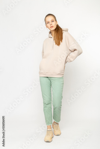 Girl in green cargo pants and beige hoodie isolated on white