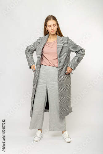 Girl in a gray coat isolated on white background