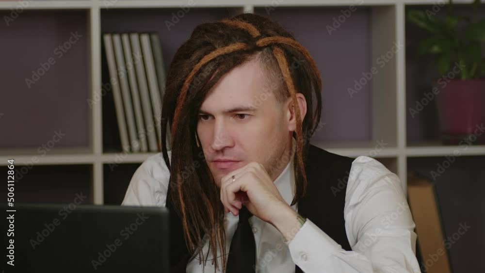 Young man in business suit working at laptop in home office. Business freelancer works remotely at modern workplace. Young man in business suit working at laptop in home office. Business freelancer works remotely at modern workplace.