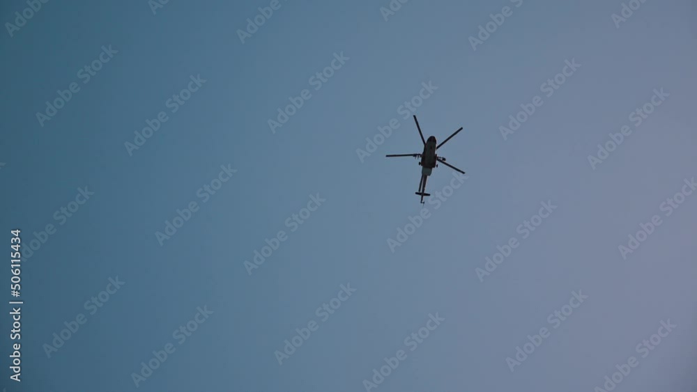 Low angle view of military helicopter flying in clear blue sky and moving very fast Low angle view of military helicopter flying in clear blue sky and moving very fast