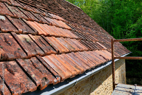 Roof of a 200 year old French cottage in process of being repaired with reclaimed tiles 