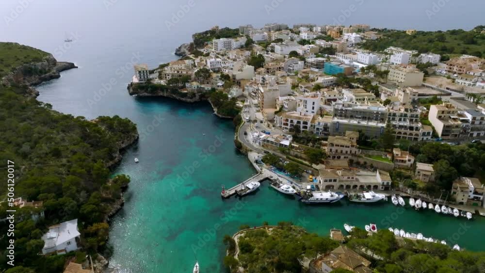 Aerial view of the fishing village in Mallorca, Spain. Boats docked by the pier. Aerial view of the fishing village in Mallorca, Spain. Boats docked by the pier.