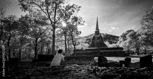 Fotografie, Obraz Black and white scenery of man tourist travel taking photo past the ancient ruined structure at Sukhothai national park