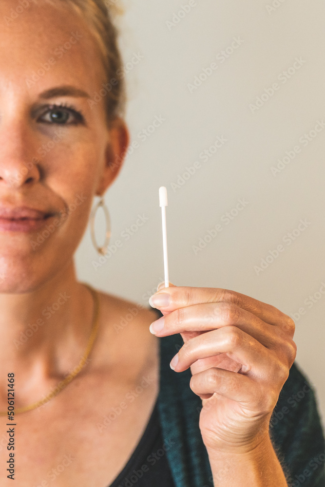 blonde Woman holding covid 19 PCR test swab clean background blonde Woman holding covid 19 PCR test swab clean background