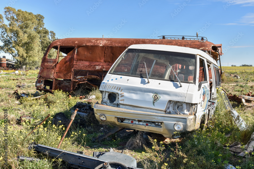 Old damaged cars in the junkyard. Car graveyard.