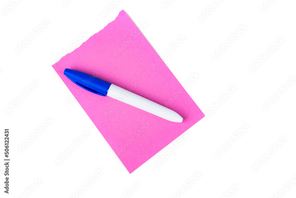 Permanent blue marker on blank pink note pad page isolated over white. Top down view Permanent blue marker on blank pink note pad page isolated over white. Top down view