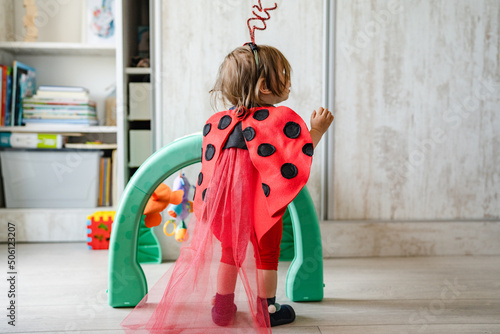 One toddler girl wearing ladybug costume playing alone at home standing copy space childhood and growing up concept full length