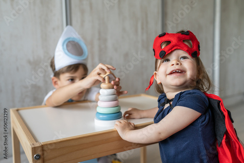 Fotografija Preschool boy and toddler girl brother and sister wearing costumes ladybug and r
