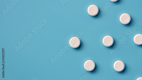 A few white pills on a blue background