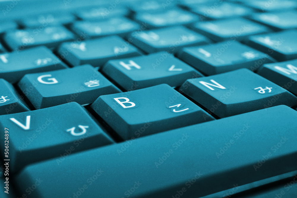 Japanese typing. Bright blue laptop keyboard. Symbols on the buttons of hiragana. Electronic commerce in Japan. IT technology and data storage. Vivid tinted computer background or wallpaper. Macro Japanese typing. Bright blue laptop keyboard. Symbols on the buttons of hiragana. Electronic commerce in Japan. IT technology and data storage. Vivid tinted computer background or wallpaper. Macro