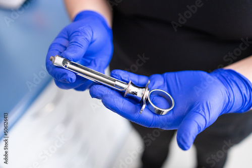 Dentist's hands preparing syringe for giving dental anesthesia to her patient. Selective focus.