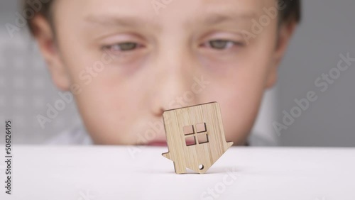 Wooden cut out house stays upside down on the table. Closeup