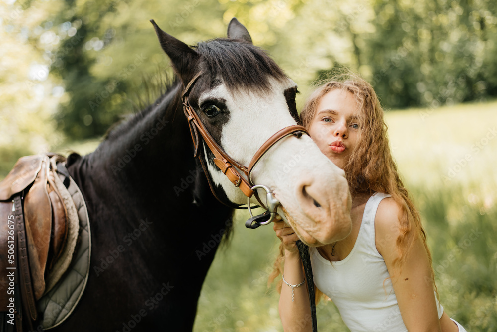 Obraz premium Portrait of a woman walking with a horse in the park.