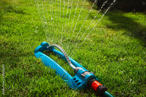 Garden lawn sprinkler on grass with water spray photo