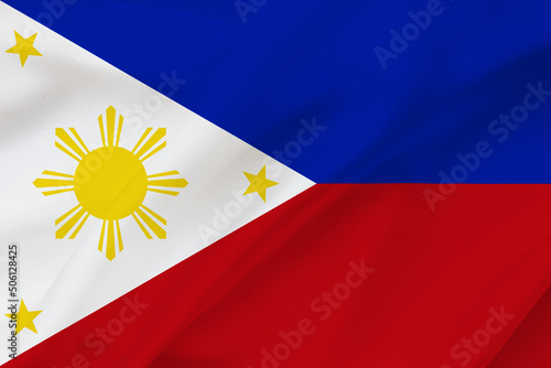Philippines flag on waving silk background. Fabric texture.