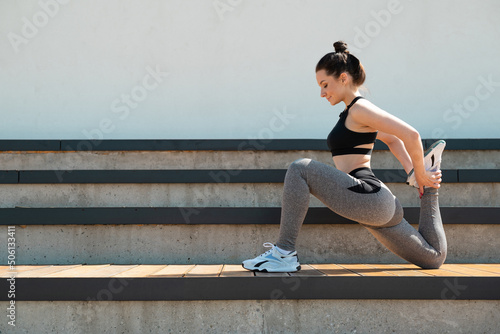 sporty girl does fitness on a sports field in the summer outdoors