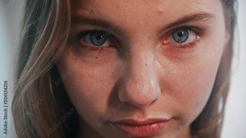 A young woman with blue eyes looks in the camera A young woman with blue eyes looks in the camera