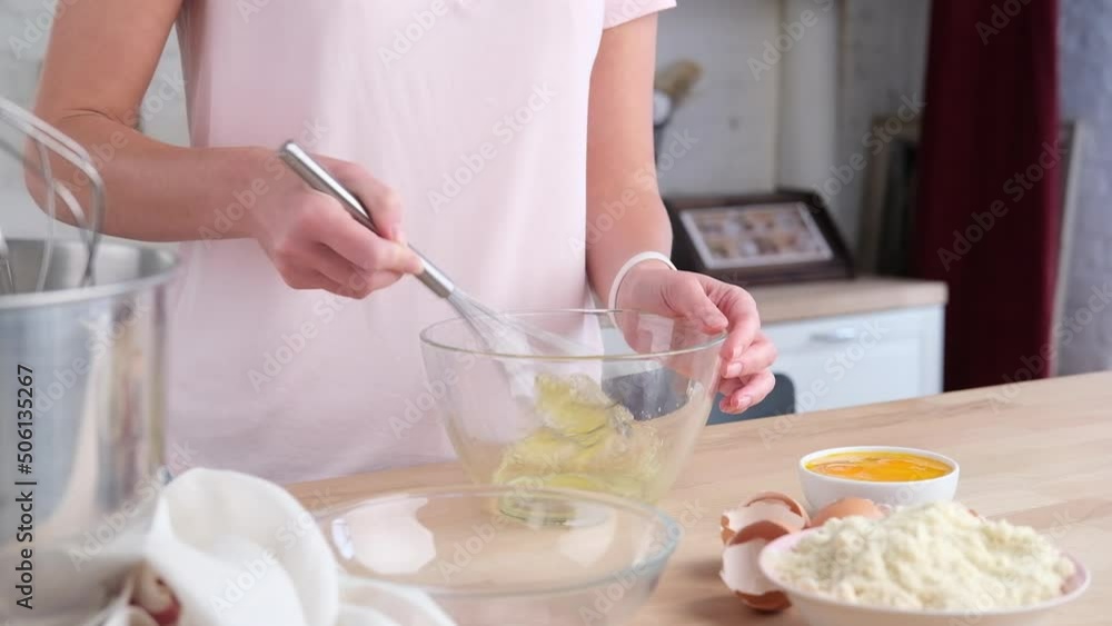 Woman whipping egg whites for making omelets, pancakes or meringue.