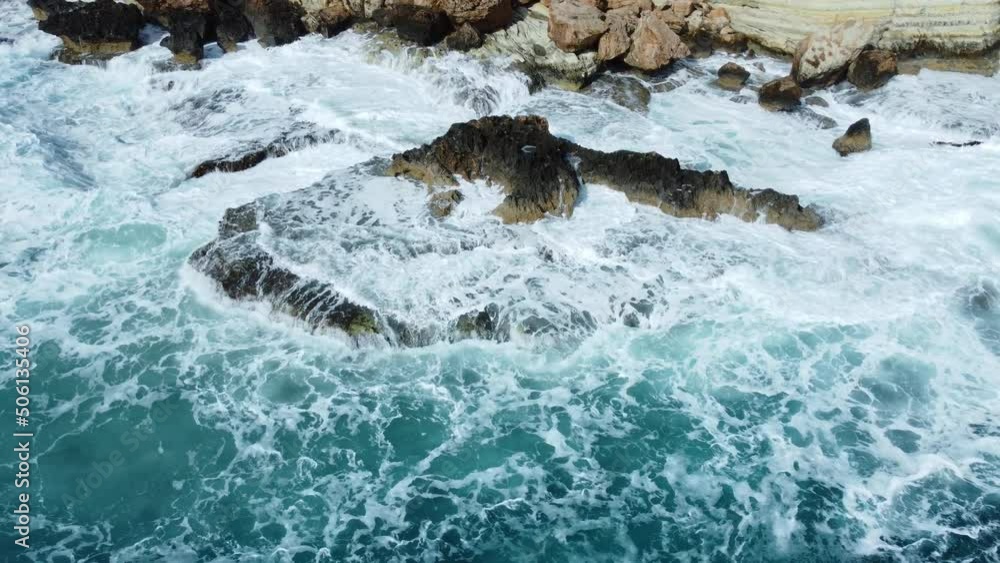 Ocean waves crash against the rocky shore, the coastline of the Mediterranean Sea during a storm, Aerial landscape of Cyprus Ocean waves crash against the rocky shore, the coastline of the Mediterranean Sea during a storm, Aerial landscape of Cyprus