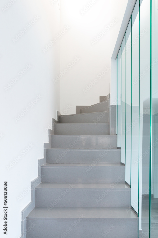 Fototapeta premium A modern staircase. Marble staircase and glass railing.