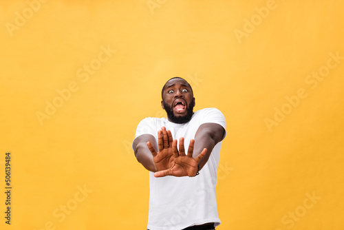 Fotografia Portrait shock and annoyed displeased young man raising hands up to say no stop right there isolated orange background
