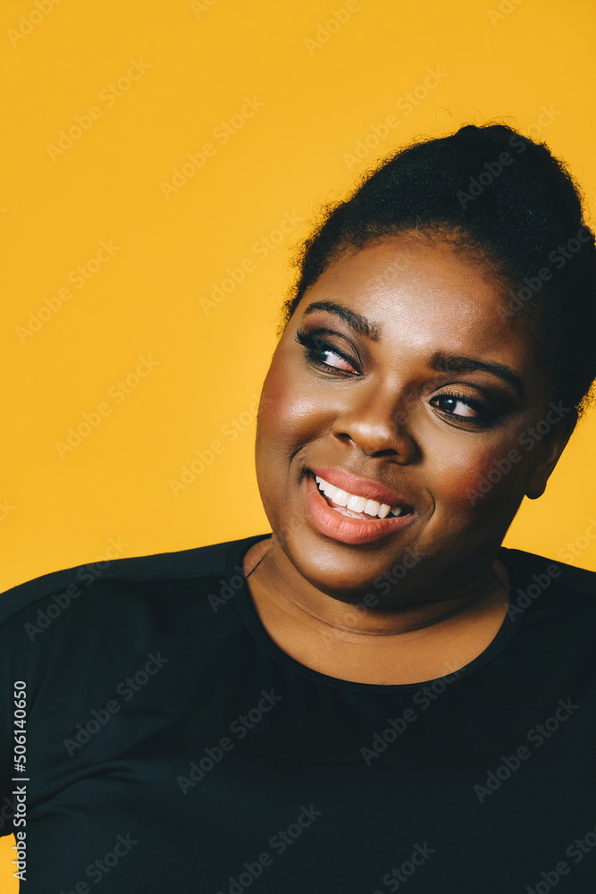 closeup portrait of a beautiful young african american woman smiling with afro hairstyle on yellow background studio closeup portrait of a beautiful young african american woman smiling with afro hairstyle on yellow background studio