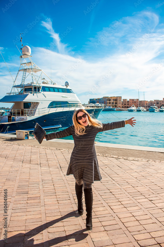 Happy woman at the marina near the yacht.