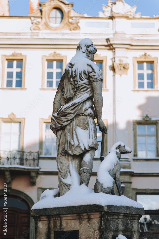 Obraz premium Statue of the goddess of hunting Diana with a dog, view from the back. Historical center of Lviv near the town hall on the square in Lviv, Ukraine.