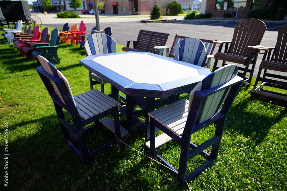 Colorful wooden lawn chairs are set up outside to be sold Colorful wooden lawn chairs are set up outside to be sold