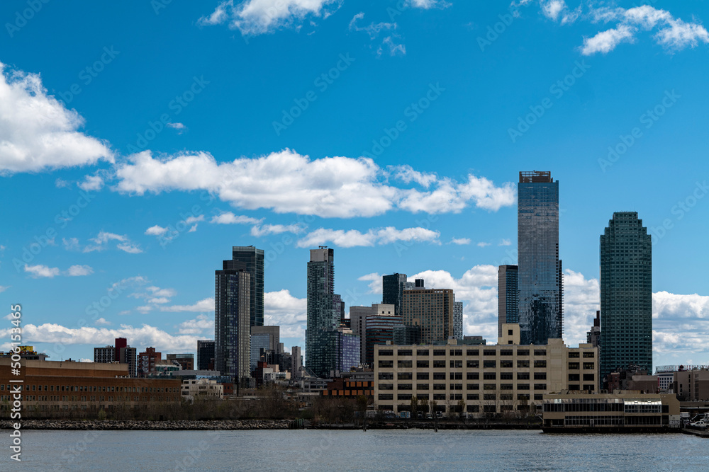 New York City skyscrapers on the river canal have a cloudy and blue sky background. High-quality photo